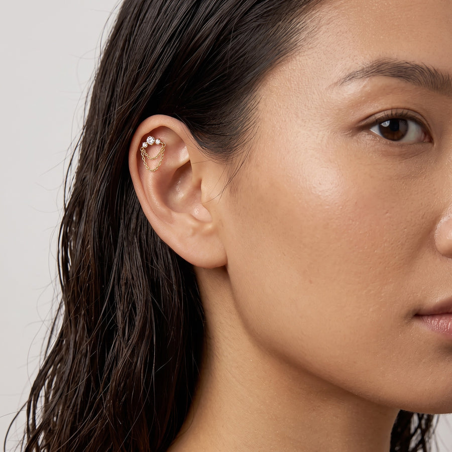 Model Image - A close-up of a woman's ear wearing a delicate gold ear cuff adorned with small white pearls, set against a clean light gray background.