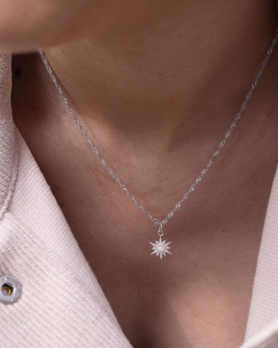 Model Image - Rhodium necklace with an opal star pendant resting at the neckline worn on model