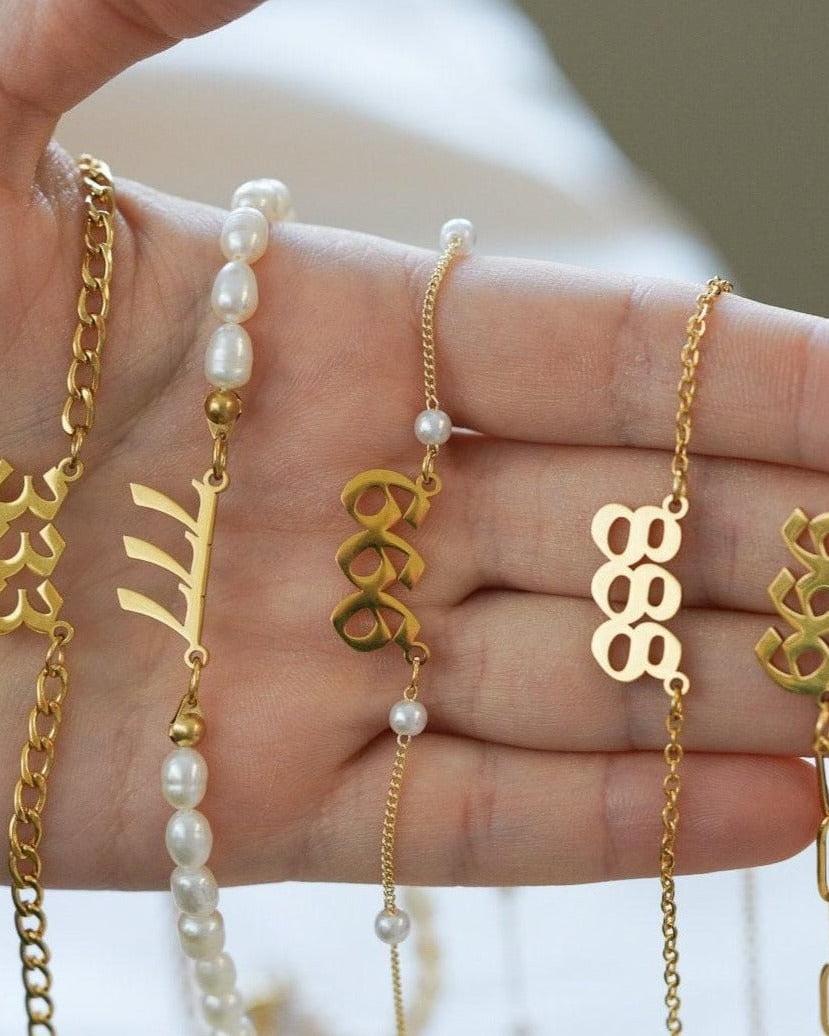 Style Image - Gold plated angel number necklaces with 888 pendants shown on a hand with chain and bead styles