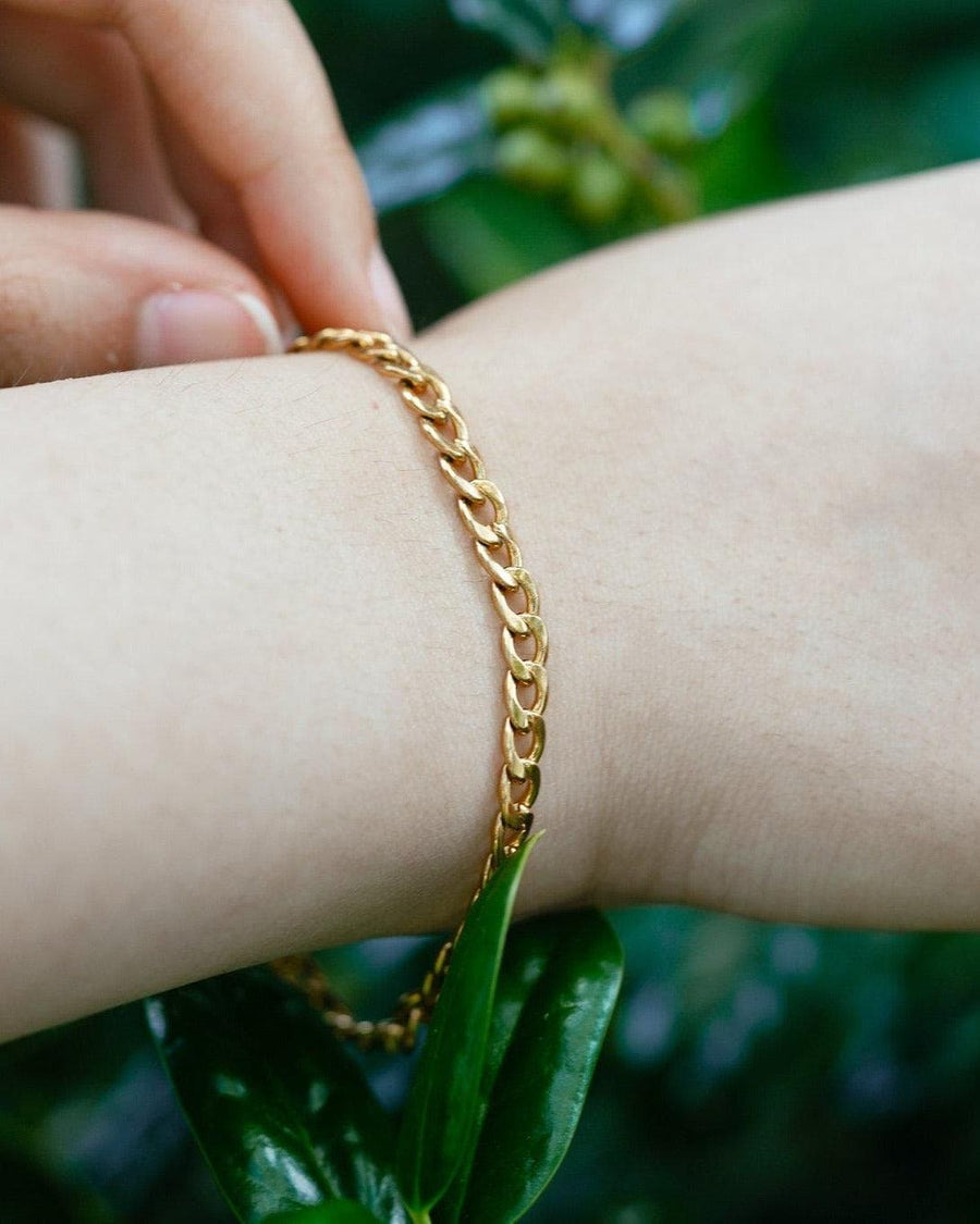 Model Image - Curb chain bracelet on a wrist with a polished gold-tone look worn on model