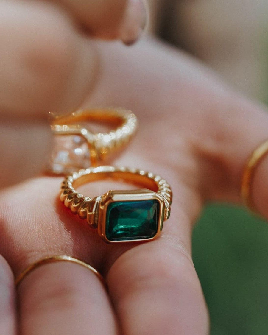 Style Image - Twisted Signet Ring with green emerald center stone and twisted band held in hand