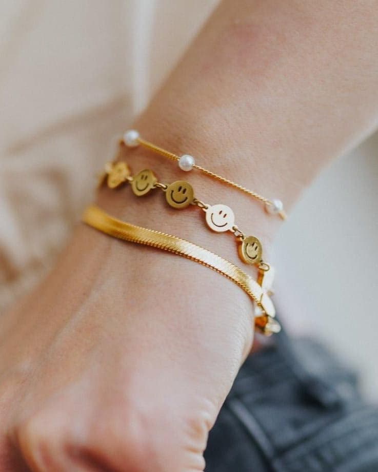 Model Image - herringbone bracelet layered with other bracelets on the wrist worn on model