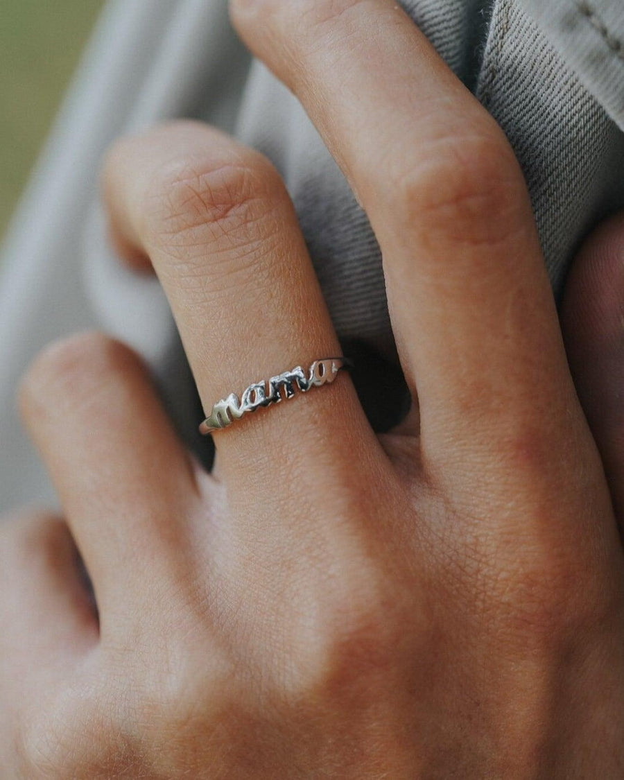 Style Image - Mama Ring in silver finish on brass worn on the hand, featuring a raised “Mama” script design