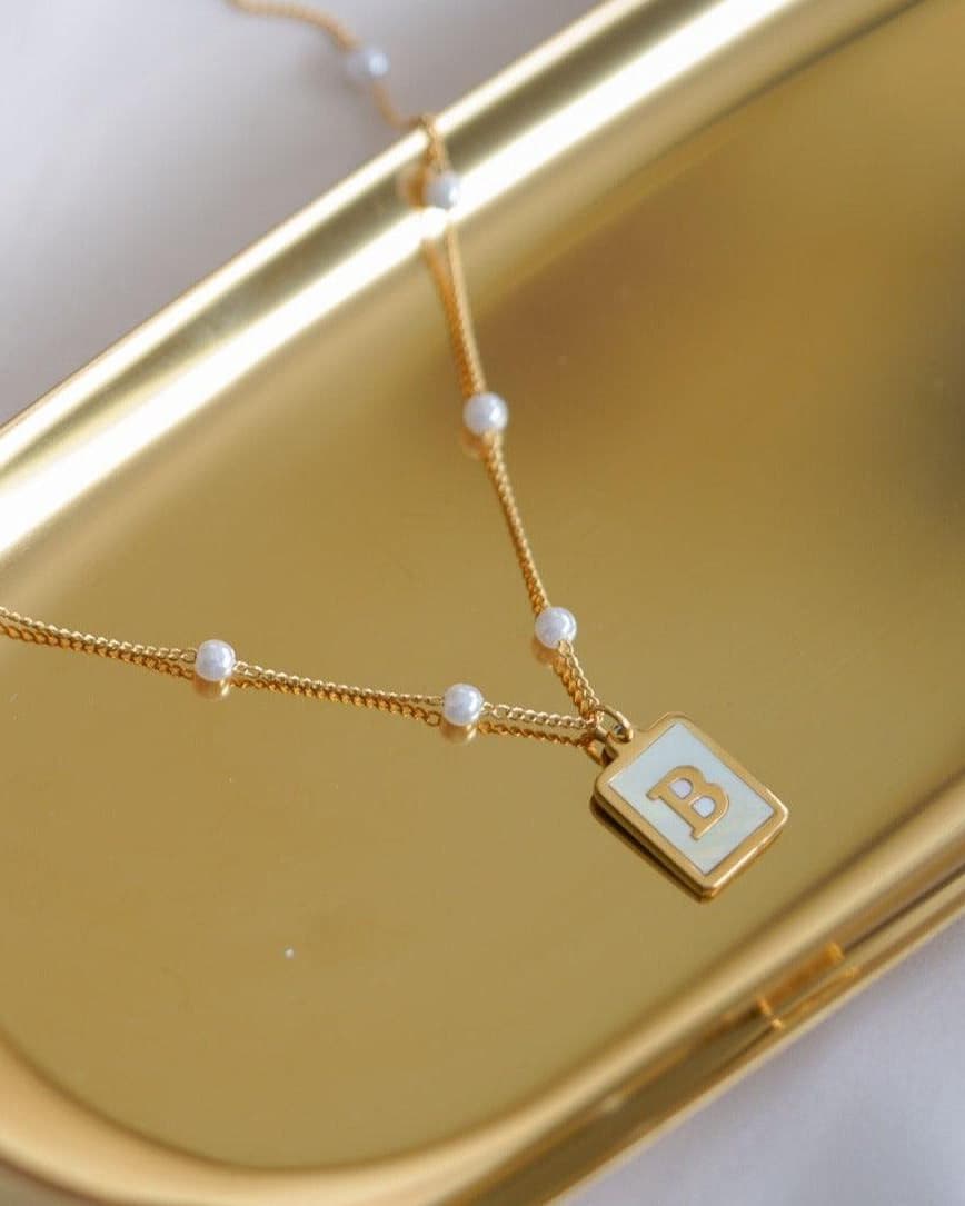 Model Image - Mother of pearl initial necklace with a B pendant and beaded chain worn on model