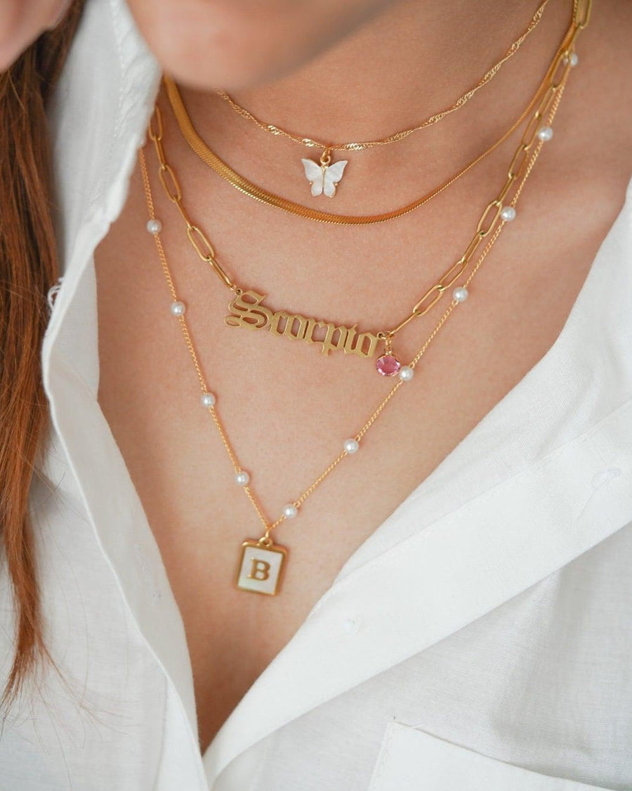 Layered necklaces with Mother of Pearl Initial Necklace featuring a B pendant on model