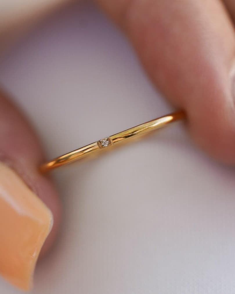Detail Image - Close-up of the 18k gold plated stainless steel Single Stackable Ring showing the slim 1.15 mm band held between fingertips