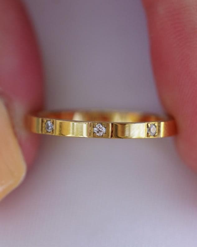 Detail Image - Trio Stackable Ring with a slim gold plated band and delicate stone accents held between fingertips