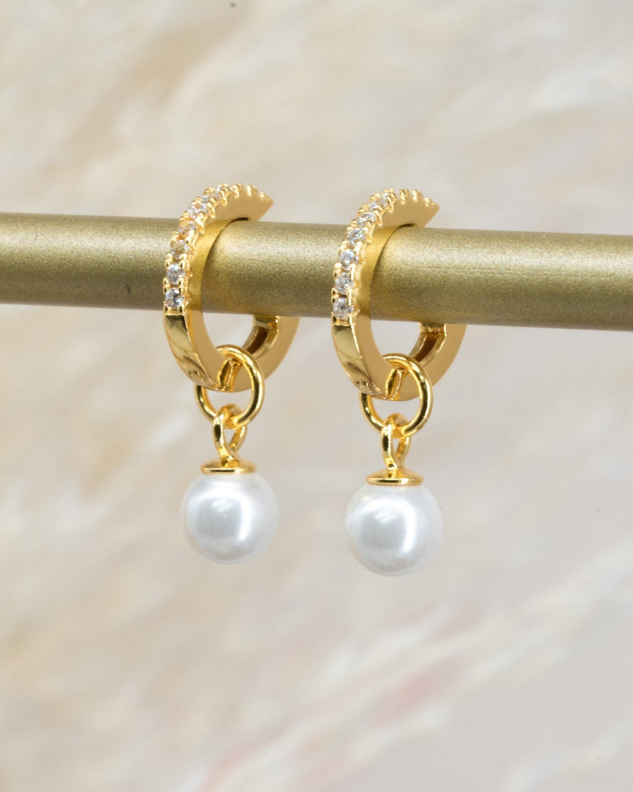 Detail Image - Pearl drop huggie earrings in 14K gold plated design on a display bar