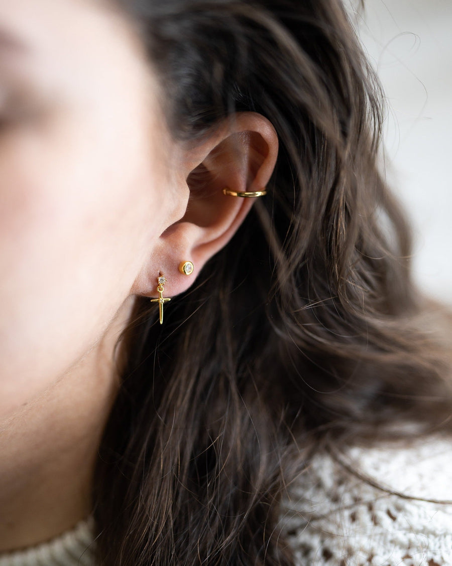 Style Image - Cross Drop Stud worn in a curated ear stack with small gold-tone earrings