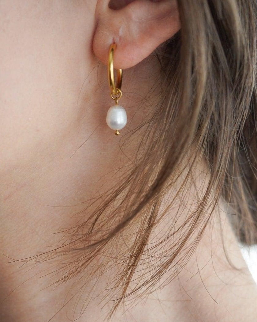 Model Image - 14K gold plated huggie hoop earring with a pearl bead drop worn on model