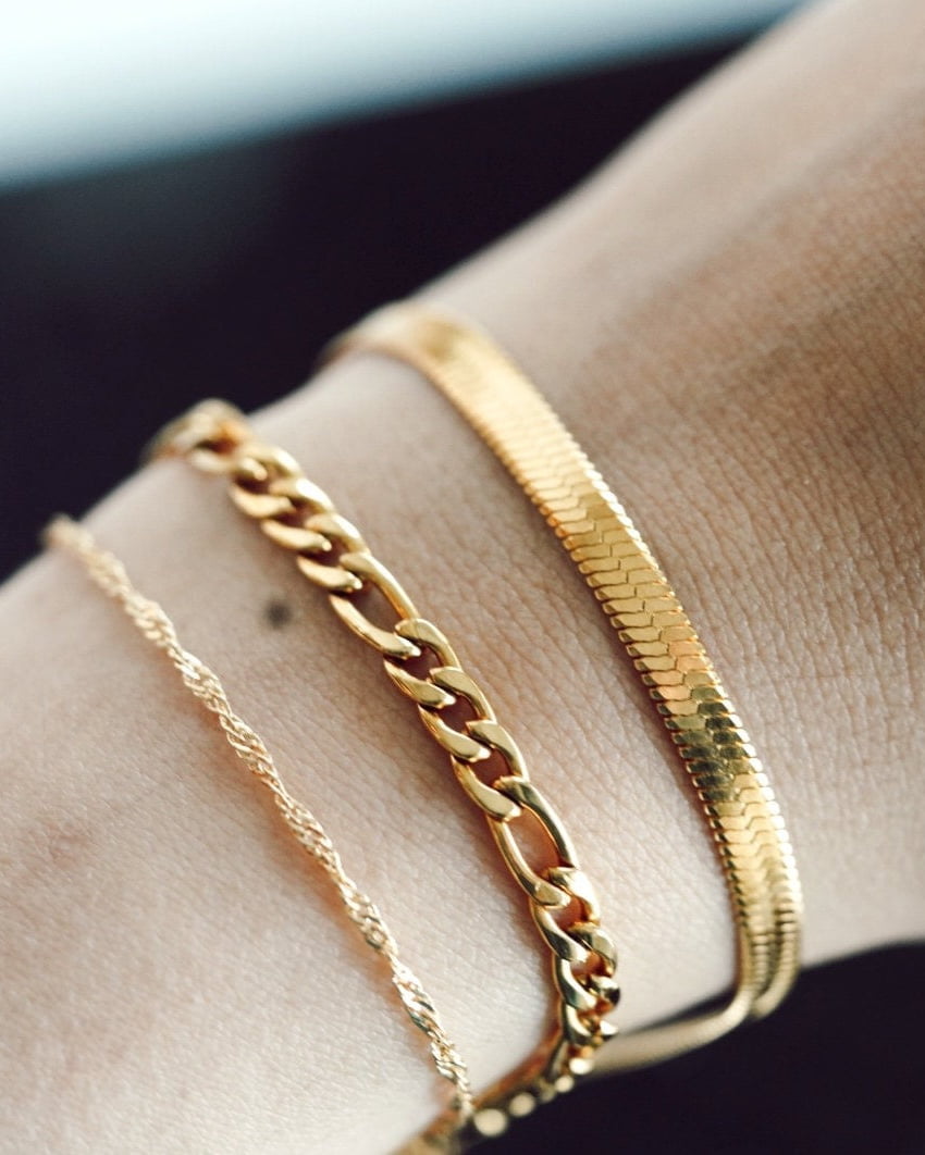 Model Image - large 14K gold plated chunky figaro bracelet styled in a bracelet stack on the wrist worn on model