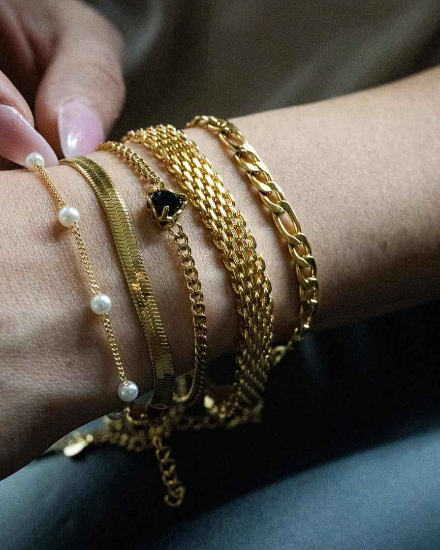 Style Image - Mini Heart Bracelet in black worn in a layered gold bracelet stack on the wrist