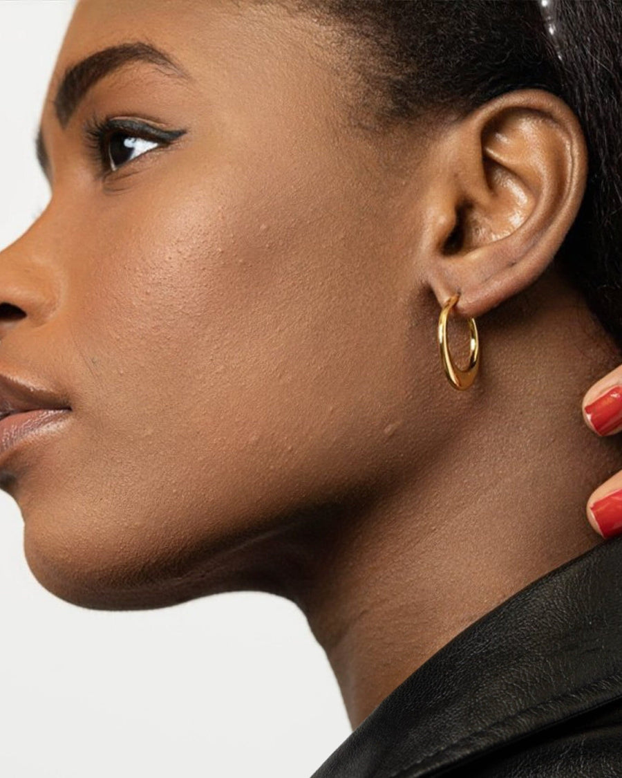 Model Image - Hollow hoop earring shown in a close-up side profile worn on model