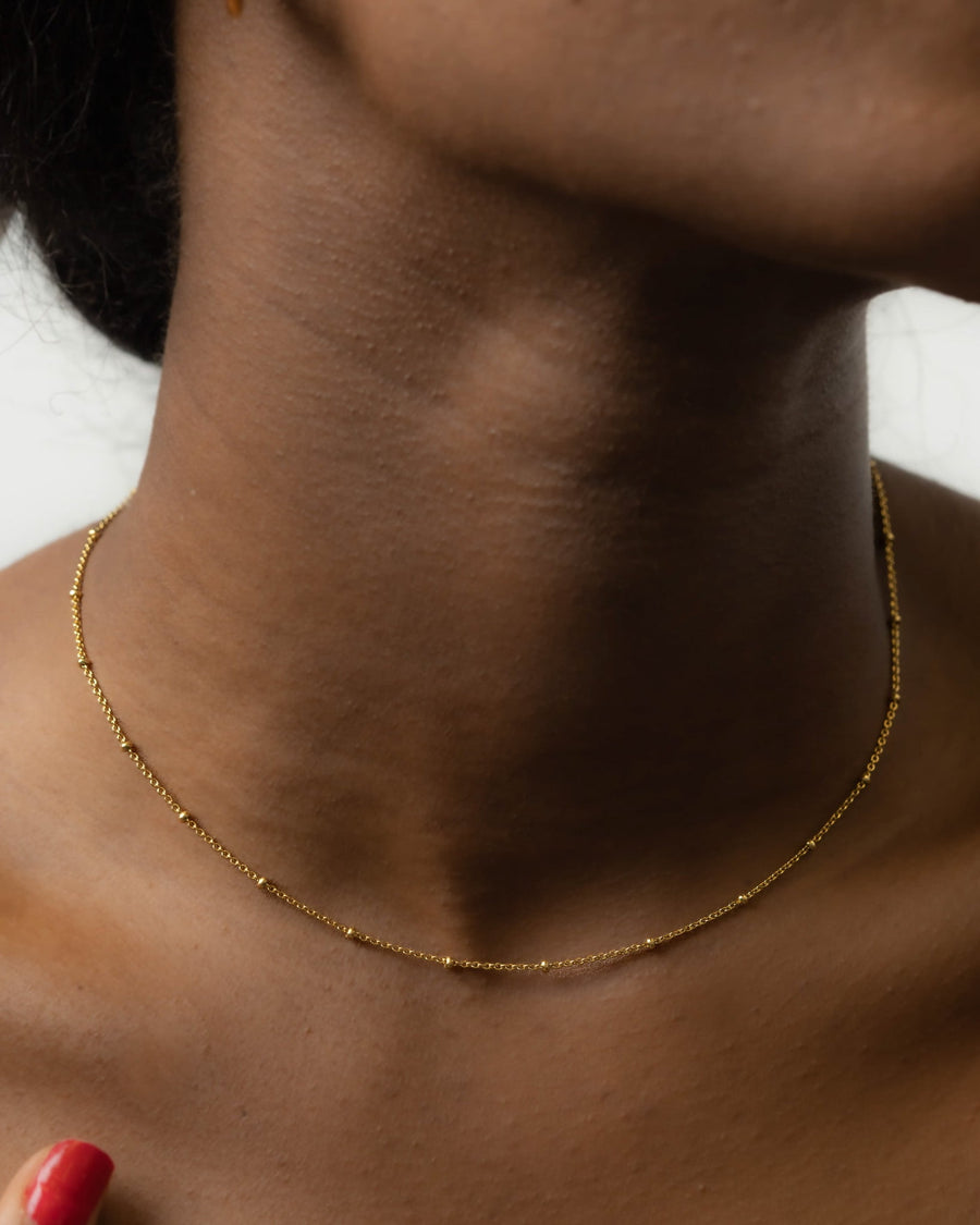 Model Image - Delicate 14K gold plated satellite chain necklace with small bead accents worn on model