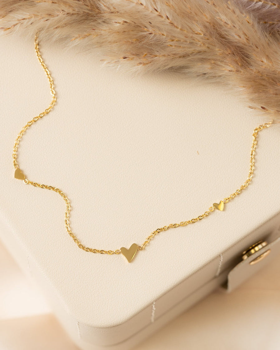 Model Image - 14K gold plated multi heart necklace with dainty heart charms on a delicate chain worn on model