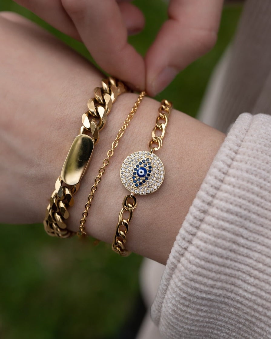 Style Image - Evil Eye Bracelet layered with gold-tone chain bracelets on the wrist