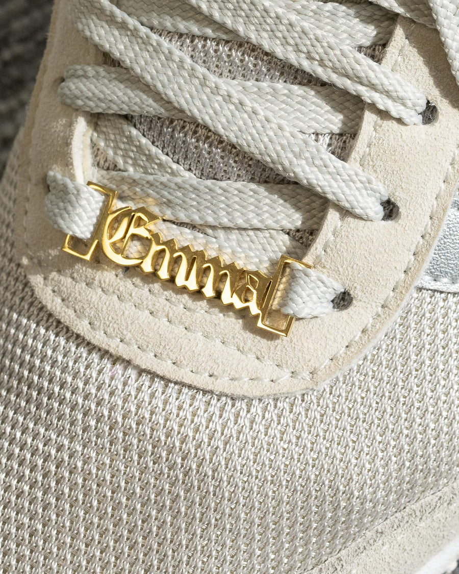 Detail Image - Customizable shoe lace charm with name lettering attached to sneaker laces in 18k gold finish