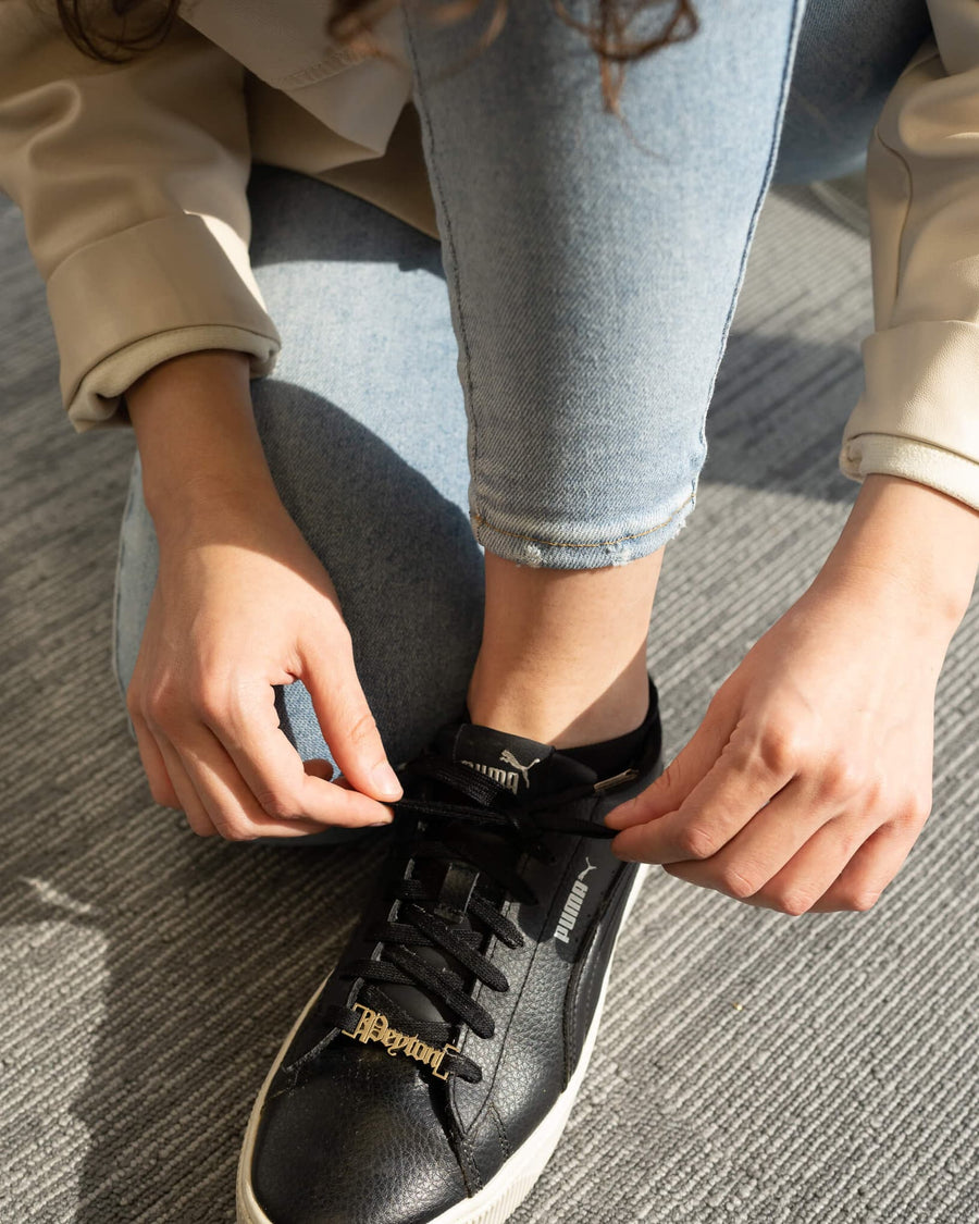 Style Image - Customizable shoe lace charm worn on black sneakers while tying laces