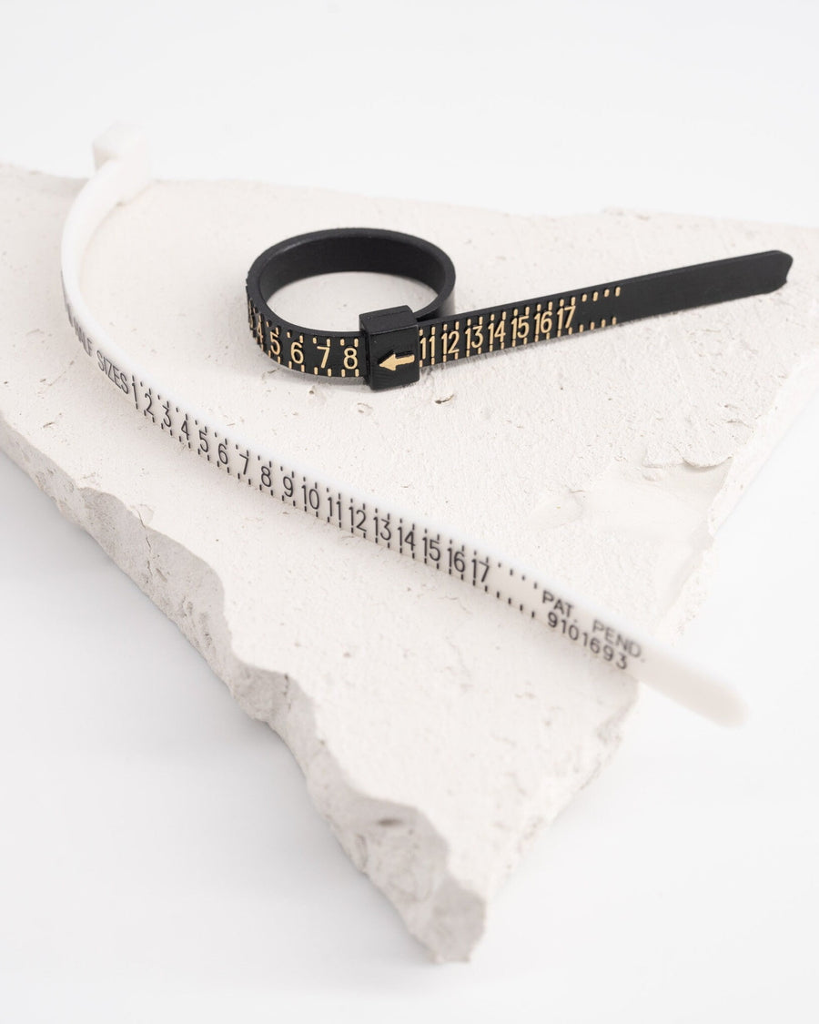 Detail Image - Flexible plastic ring sizer with US size markings on a textured white surface