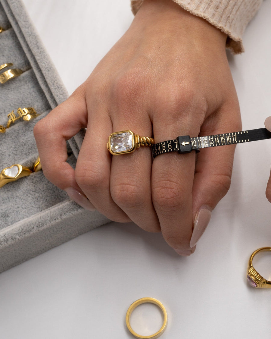 Detail Image - Flexible plastic ring sizer wrapped around a finger to measure US ring size.