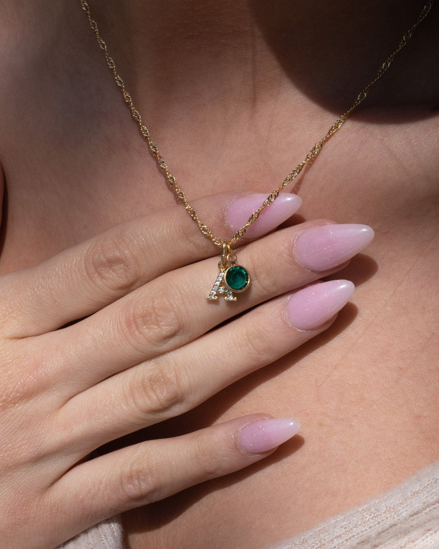 Model Image - 14K gold plated birthstone initial necklace with a pavé letter pendant and small round charm worn on model