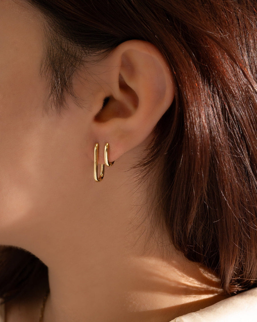 Style Image - 14K gold plated U shaped earrings shown worn on the ear in a layered hoop look