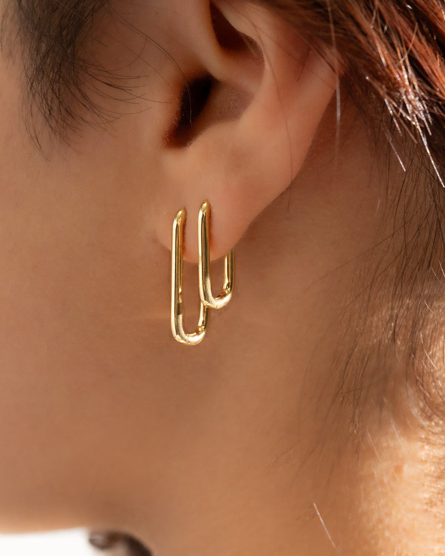 Style Image - 14K gold plated U shaped earrings worn together on the ear in a layered hoop look