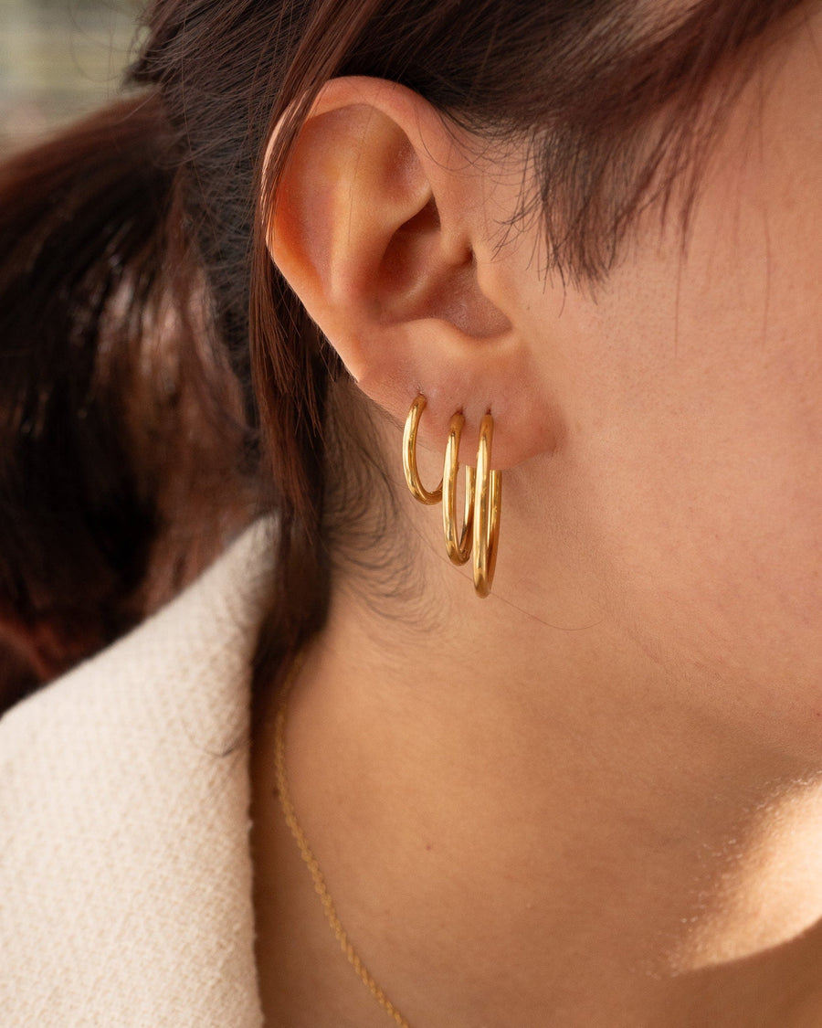 Style Image - Gold plated hoop earrings worn stacked on the ear in assorted sizes.