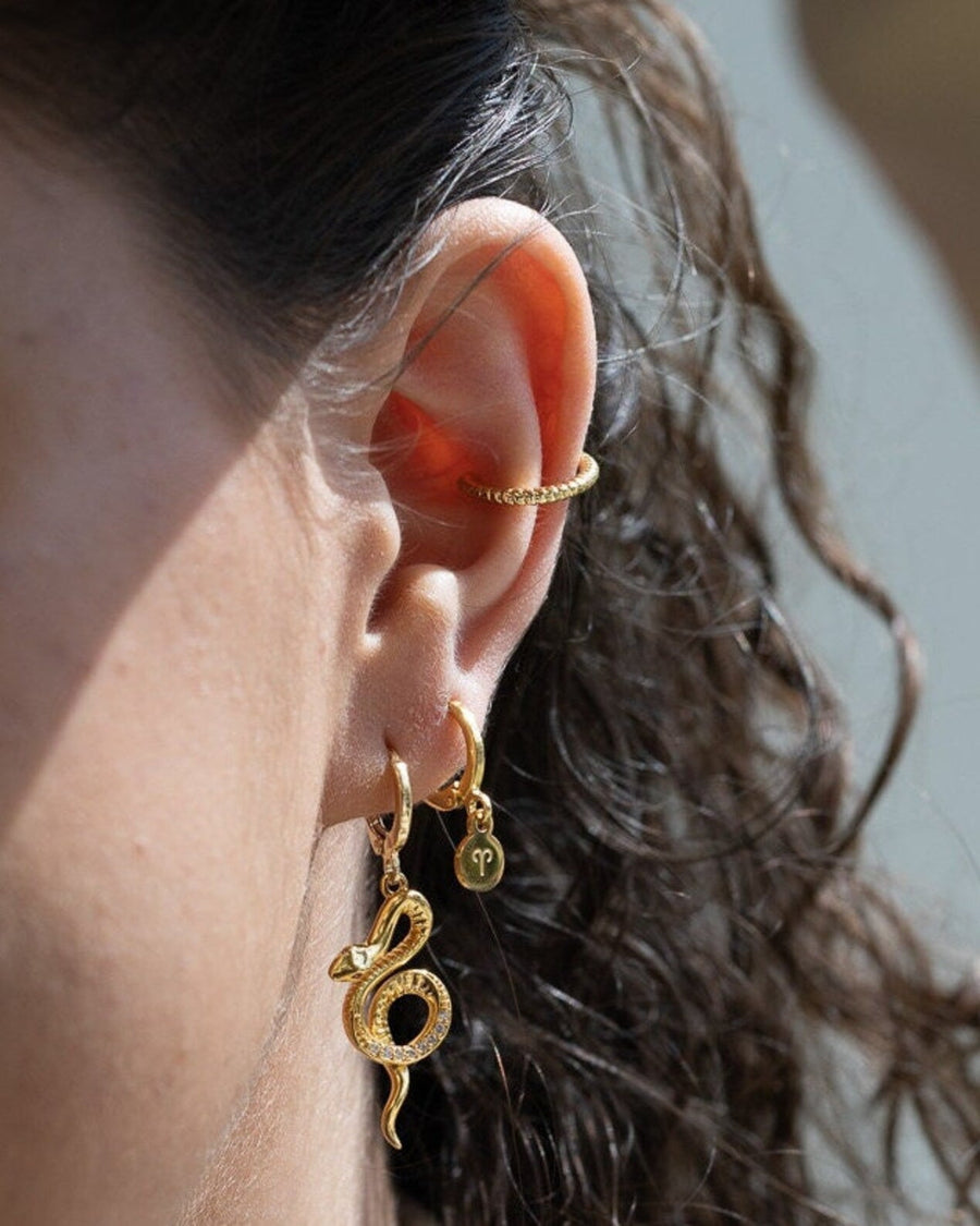 Style Image - Twisted 14K gold plated ear cuff worn with layered gold earrings on the ear