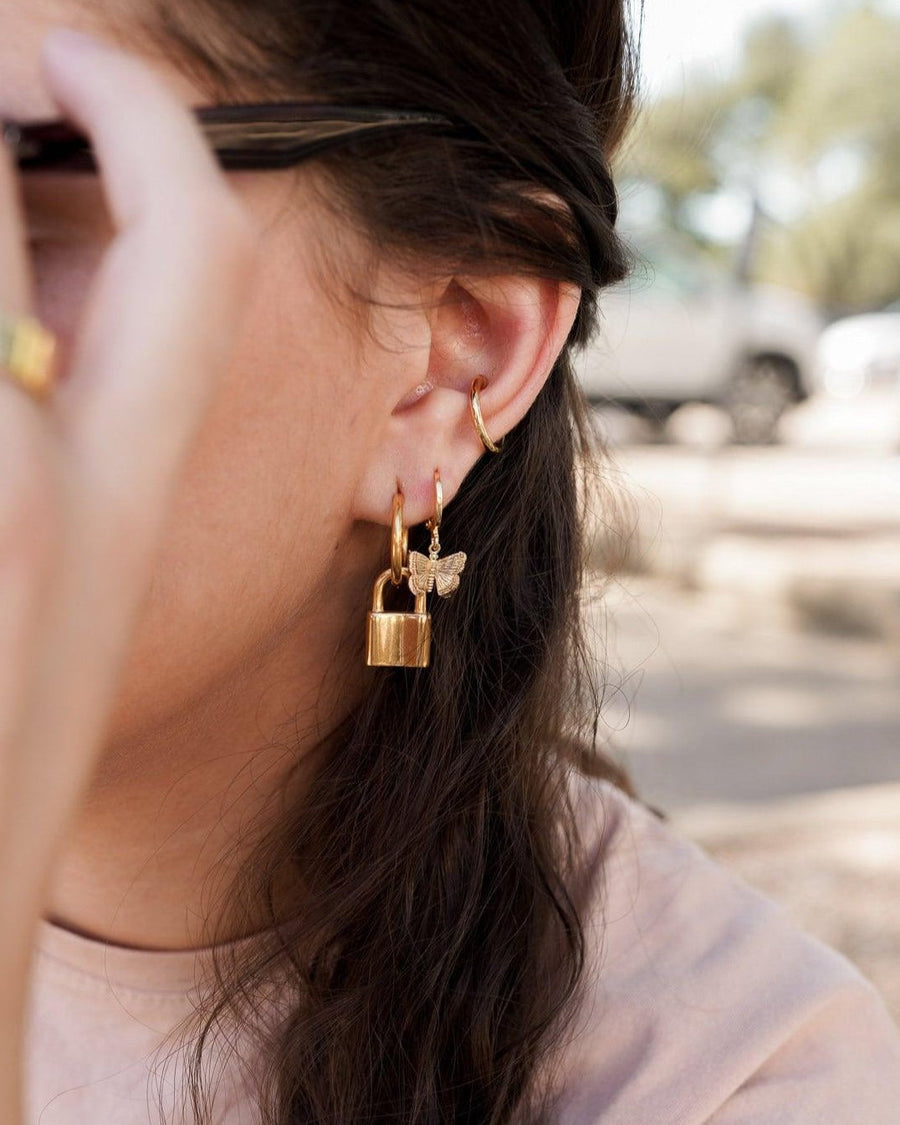 Style Image - Dainty butterfly earring worn in a layered ear stack with hoop earrings
