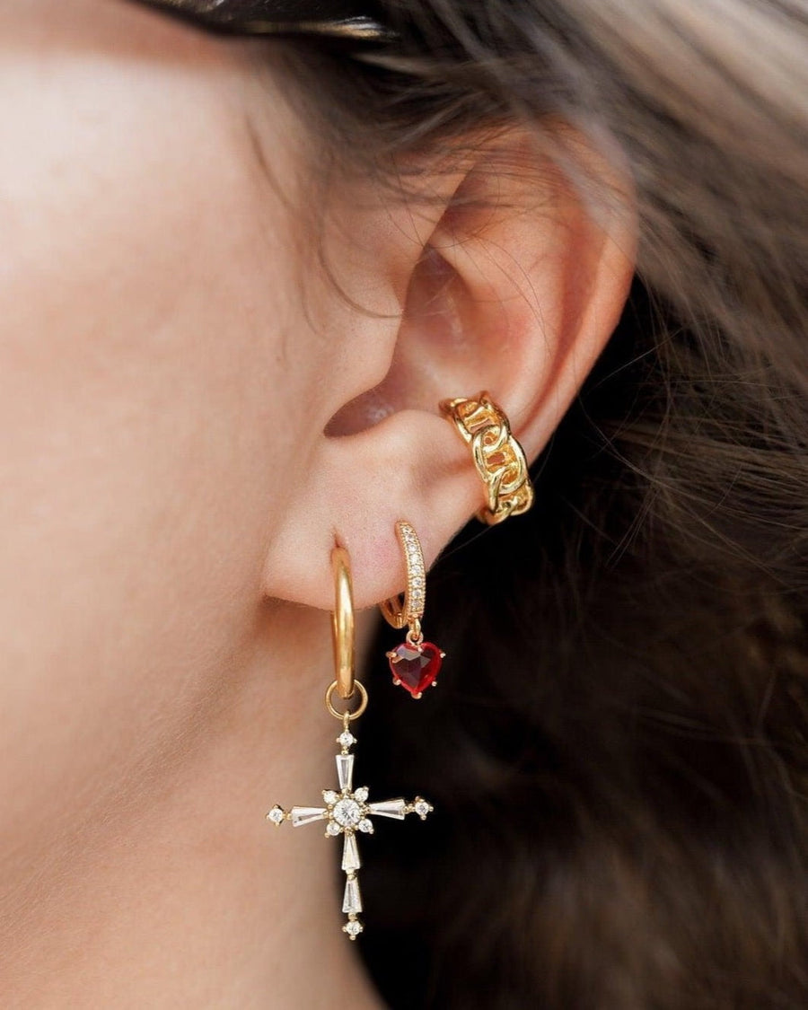 Model Image - Rhodium CZ cross drop earring styled on an ear with additional hoop and stud earrings worn on model