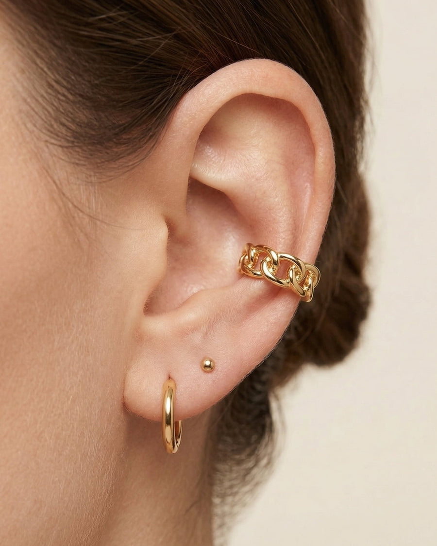 Model Image - Curb chain ear cuff styled along the outer ear with small gold earrings worn on model