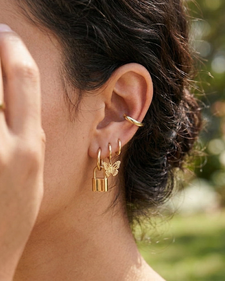 Model Image - Plain 14K gold plated ear cuff styled on the upper ear with additional earrings visible worn on model