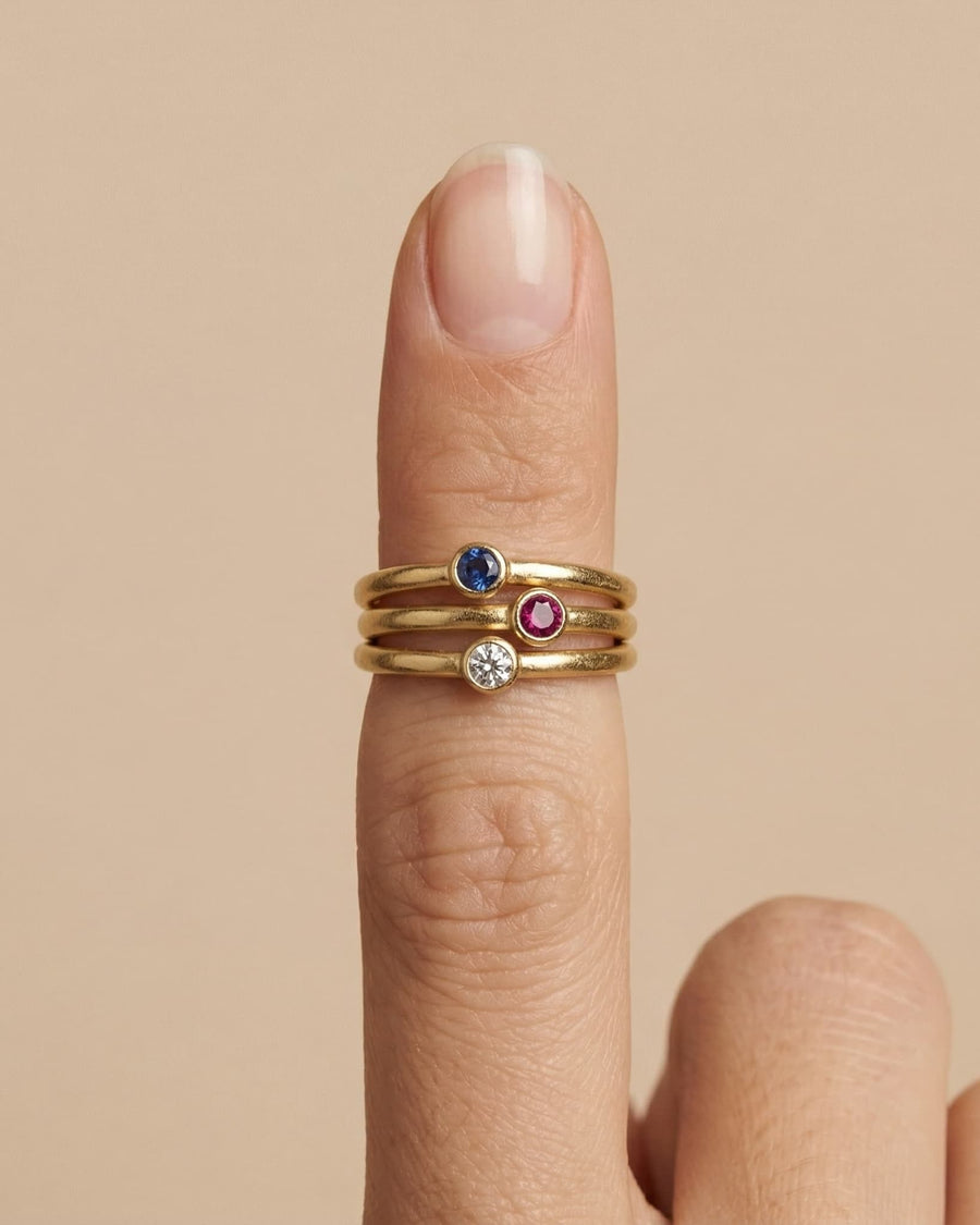 Style Image - Stackable birthstone rings worn together on a finger, including the February amethyst design in 14k gold plated material