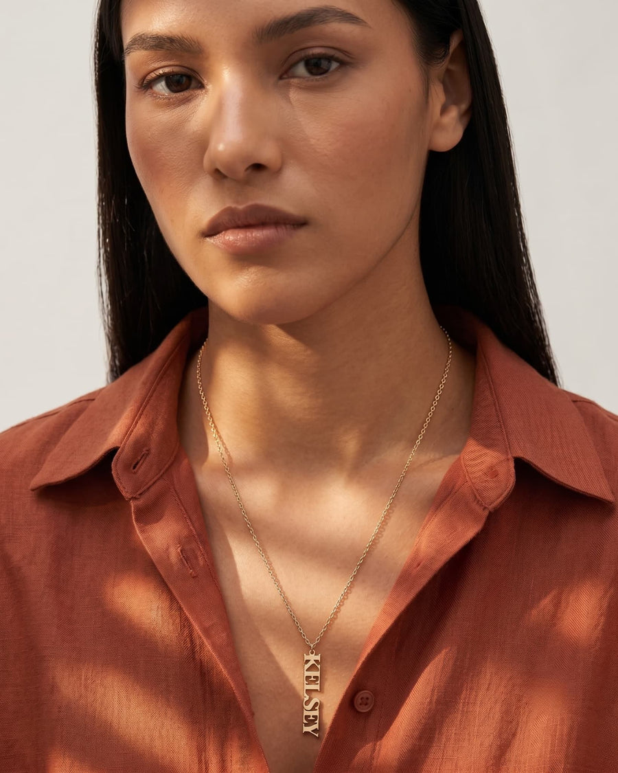 Model Image - 14K Gold vertical personalized name necklace with a slim name plate worn on model