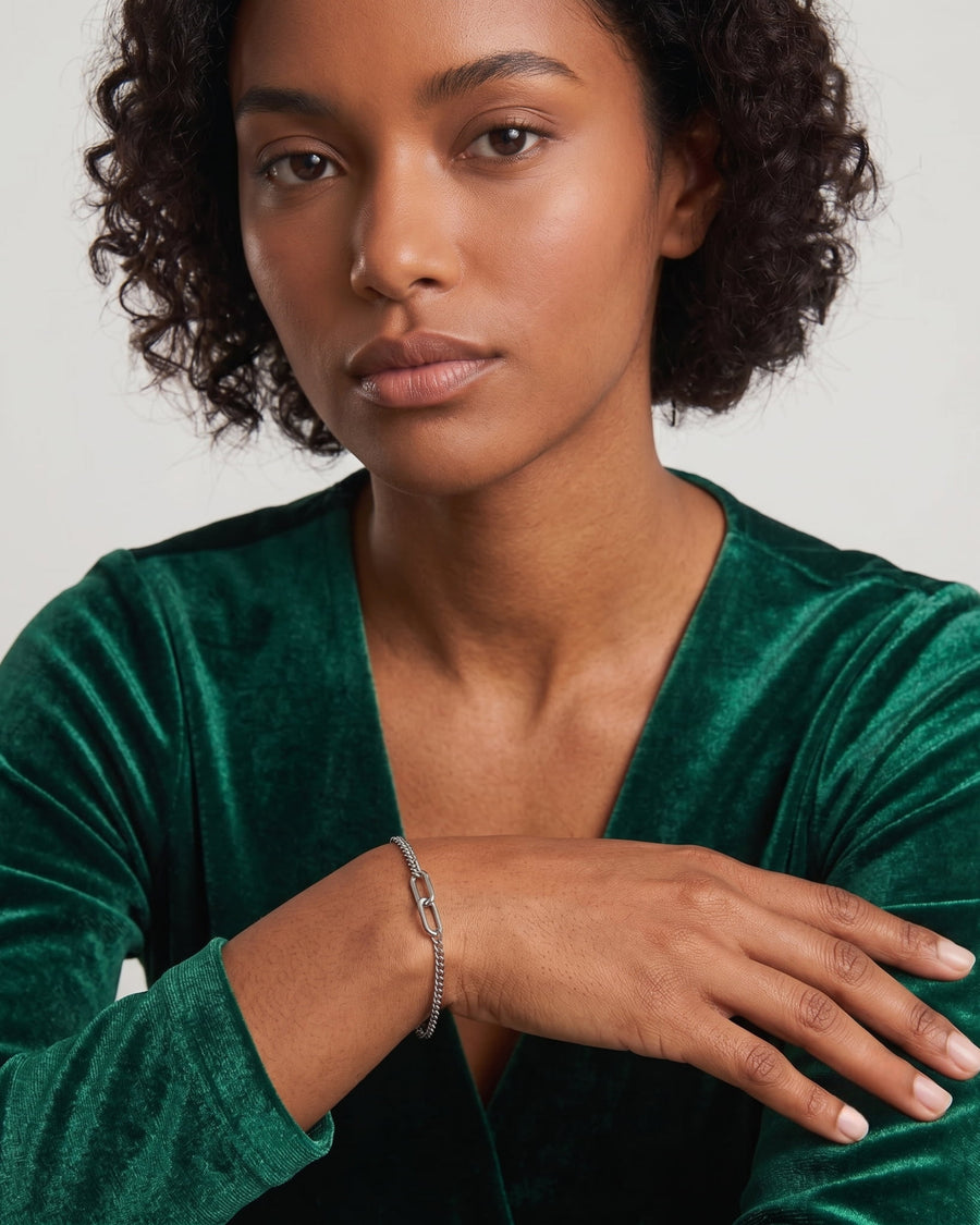 Model Image - silver baby curb bracelet on wrist with green long-sleeve top worn on model