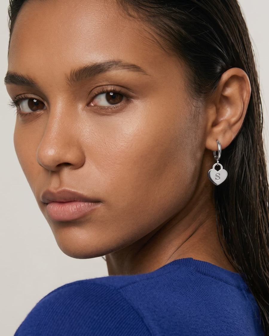 Model Image - rhodium engravable heart drop earring with a 12 mm hoop and slim heart pendant shown at the ear worn on model