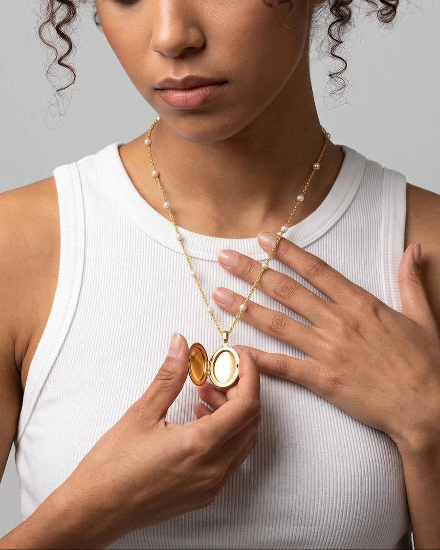 Style Image - 18k gold engravable oval locket necklace opened on a pearl bead chain worn at the neckline