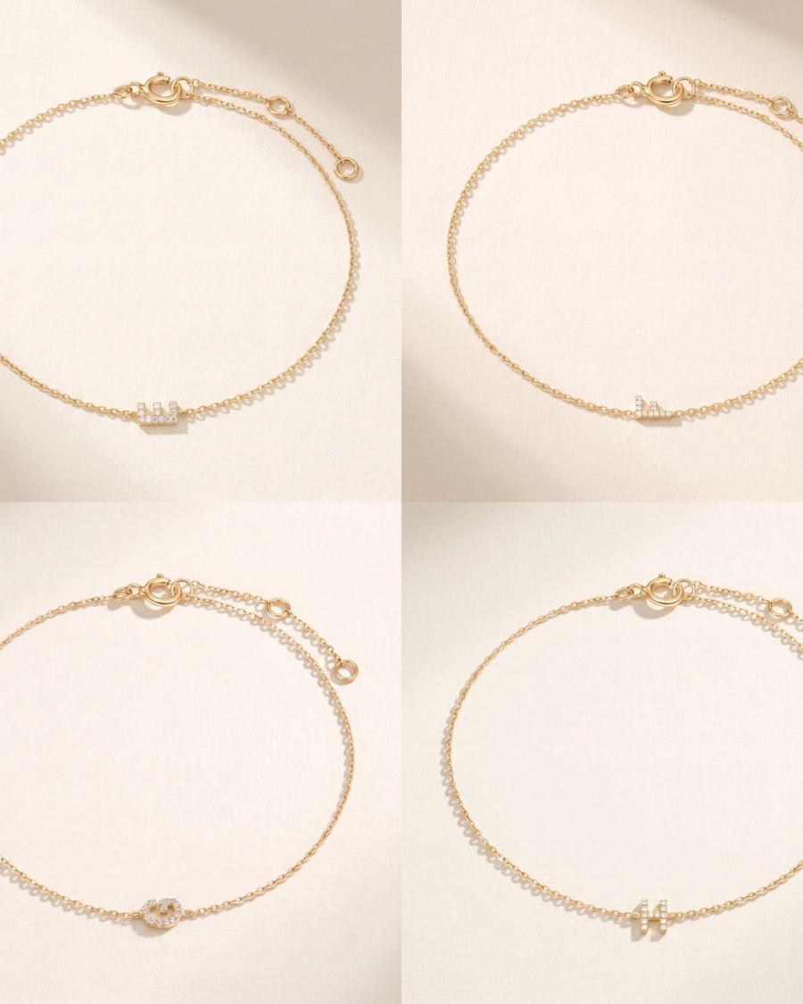 Style Image - Four 14k solid gold pave diamond initial bracelets with delicate cable chains and extender clasps on a soft neutral background.
