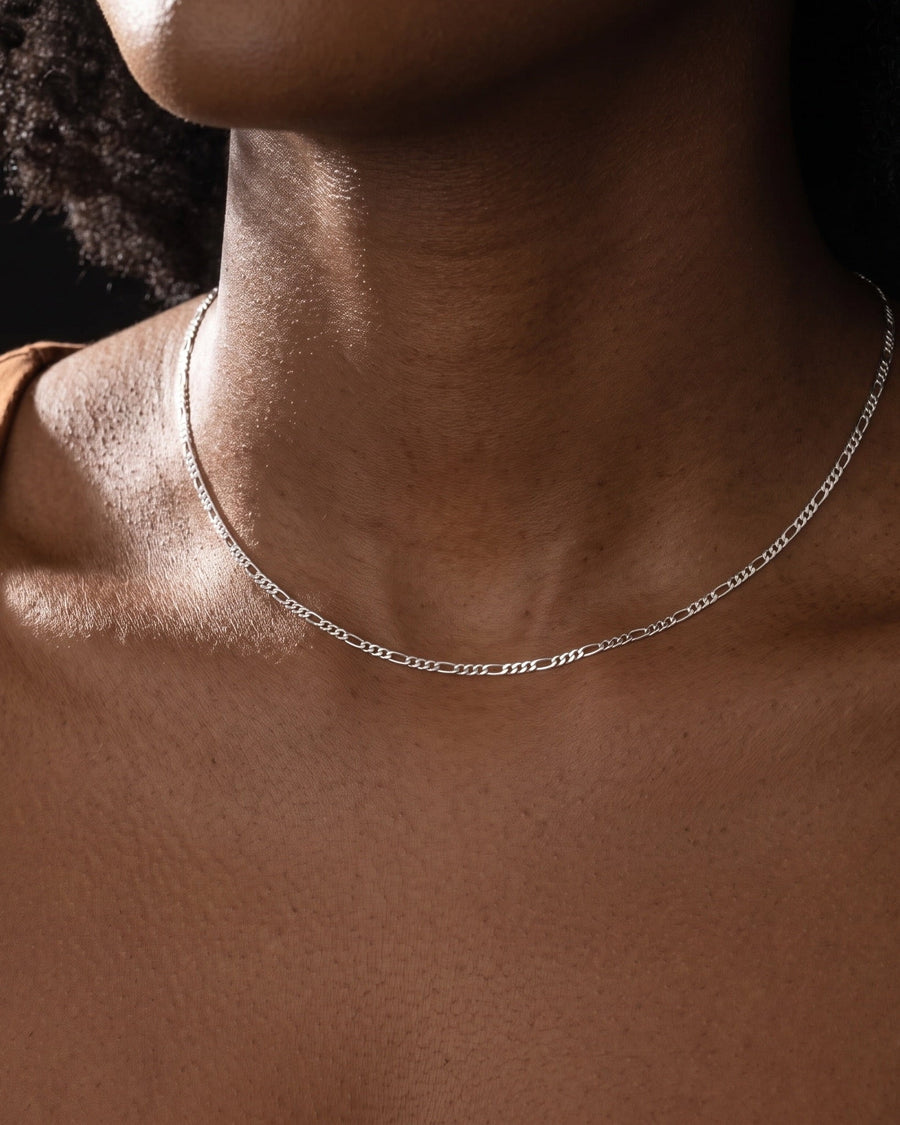 Model Image - Dainty rhodium thin Figaro chain necklace resting at the collarbone worn on model