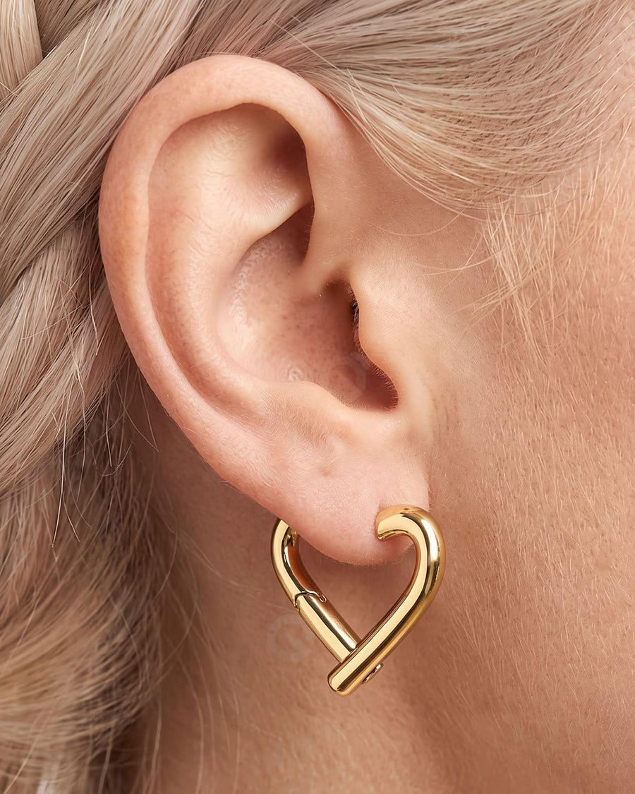 Model Image - 14K gold heart hoop earring with an open silhouette shown on the ear worn on model