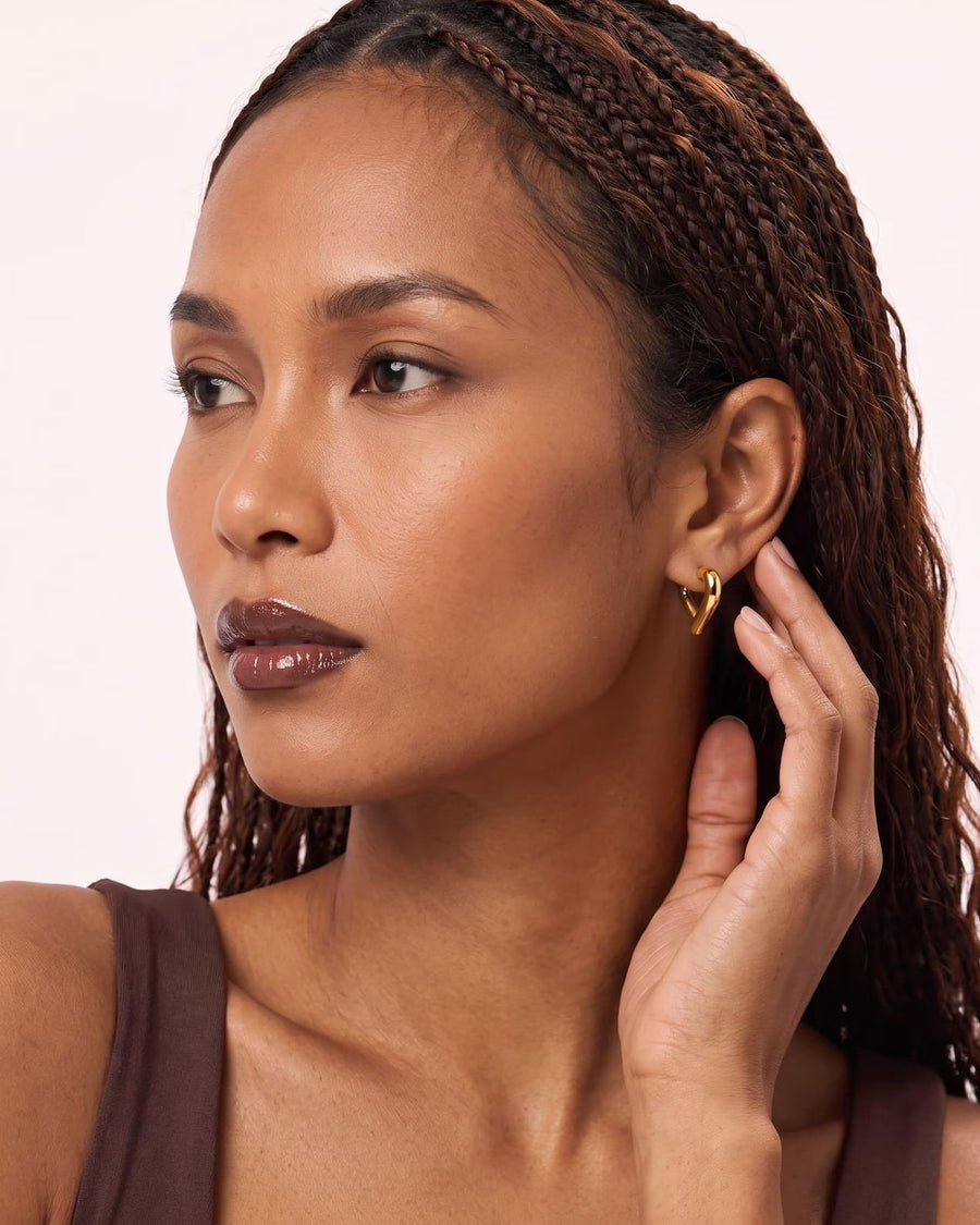 Style Image - 14K gold heart hoop earring worn on the ear, showing its open hoop shape and polished clasp look