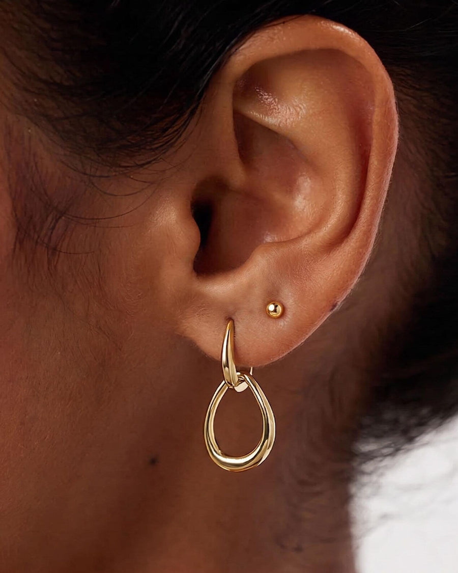 Style Image - 14K gold teardrop hoop earring worn on ear with sleek open silhouette and small stud accent