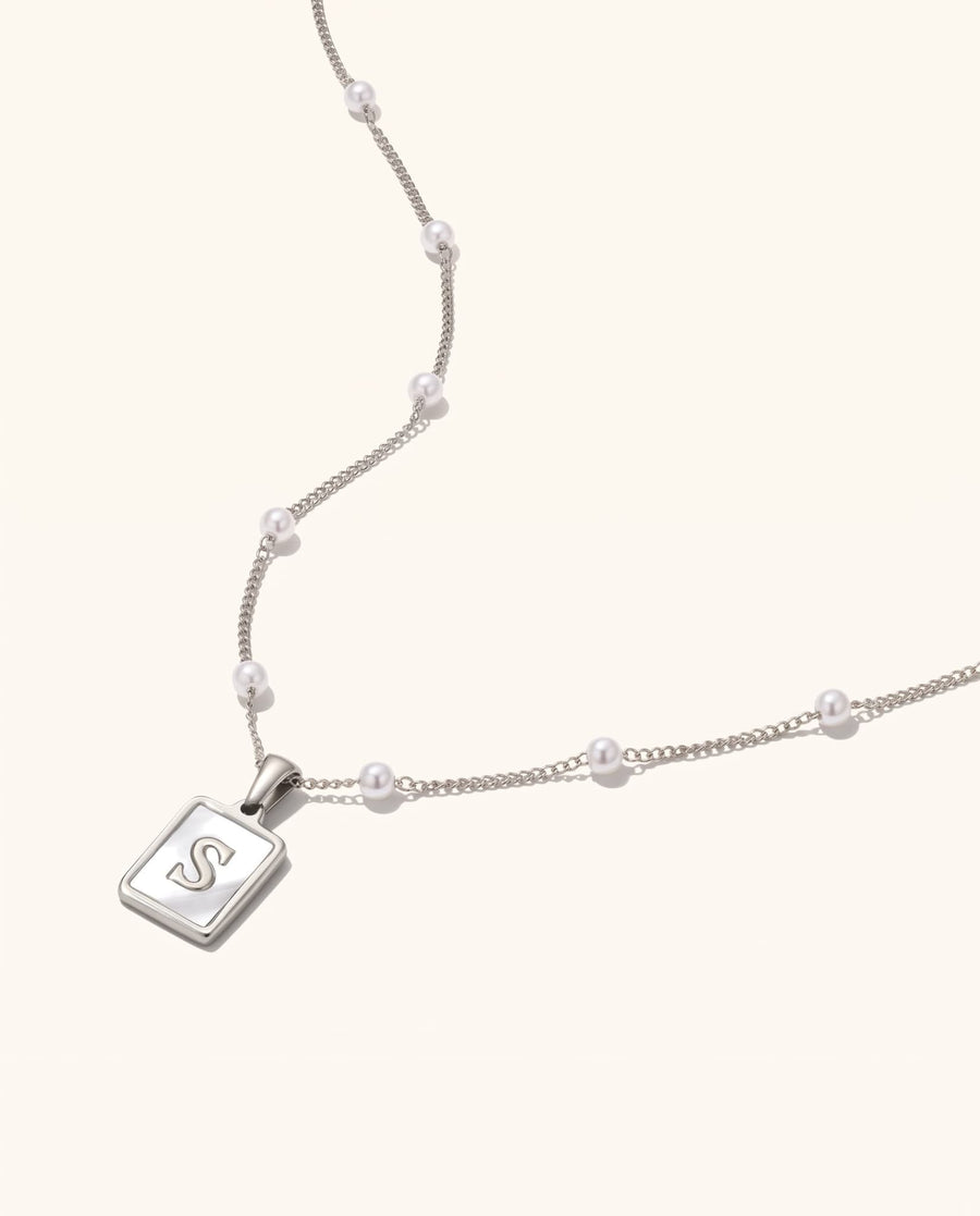 Main Image - Mother of pearl initial necklace with an S pendant and beaded chain detail on a neutral background