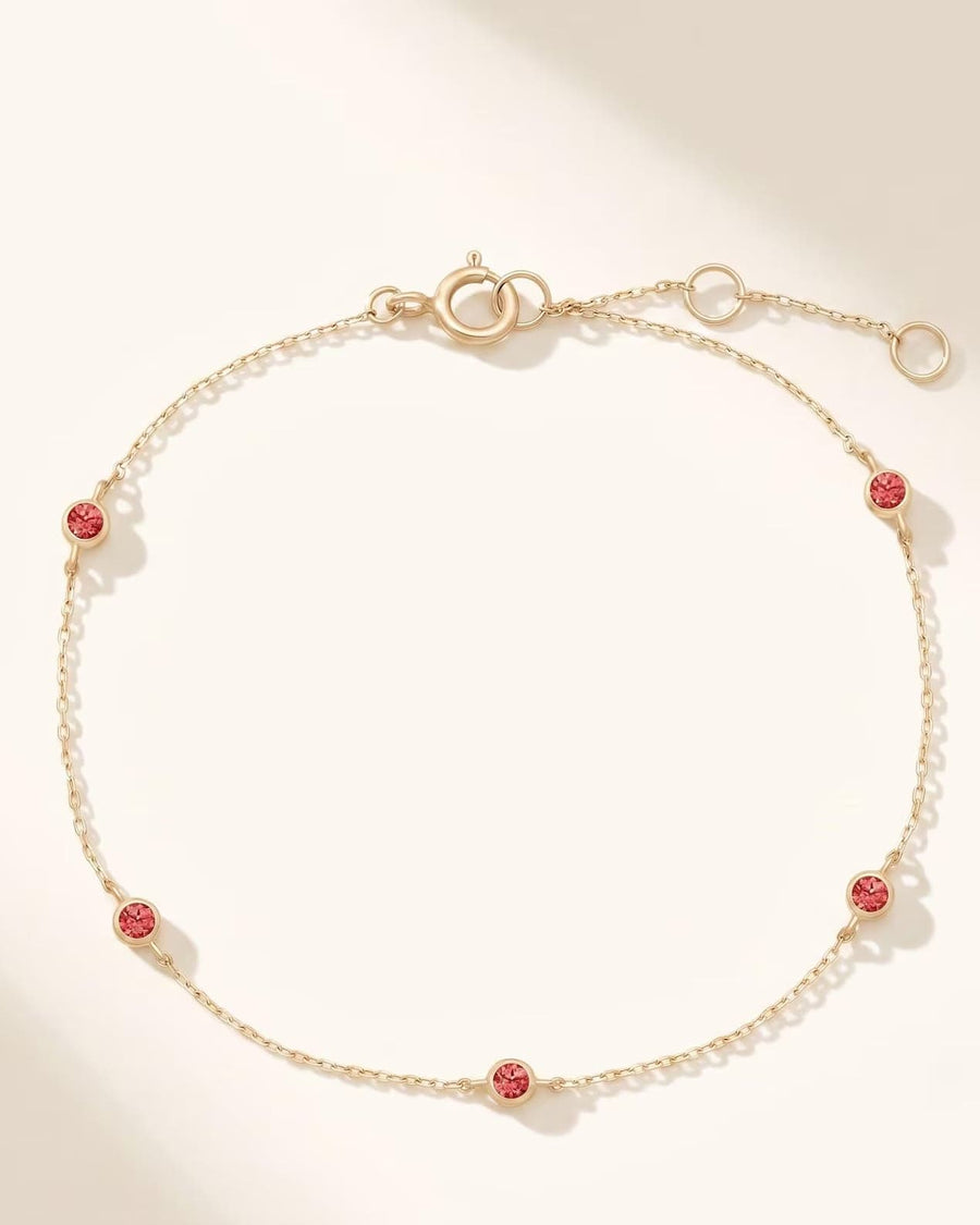 Detail Image - 14k solid gold birthstone bezel bracelet with five ruby gemstones spaced along a fine chain and 6 to 7 inch adjustable length.