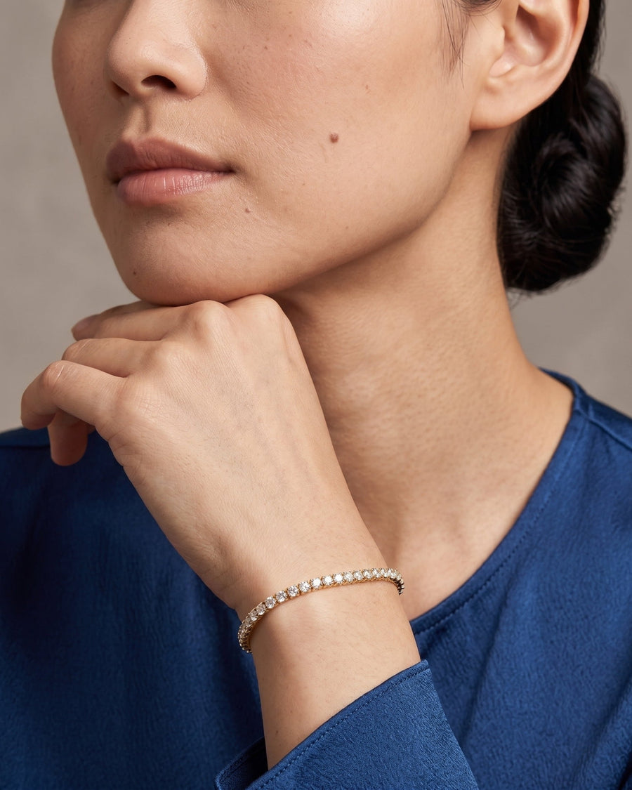 Style Image - 14k solid gold lab-grown diamond tennis bracelet worn on the wrist with a blue sleeve